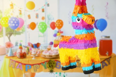 Image of Bright festive pinata hanging indoors at birthday party, space for text