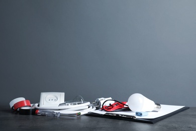 Set of electrician's tools on table against gray background. Space for text