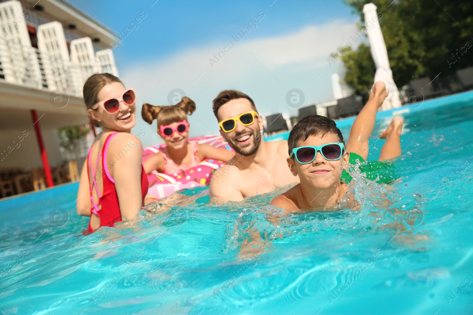 Photo of Happy family in swimming pool on sunny day