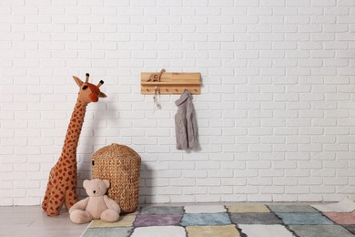 Beautiful children's room with white brick wall and toys, space for text. Interior design