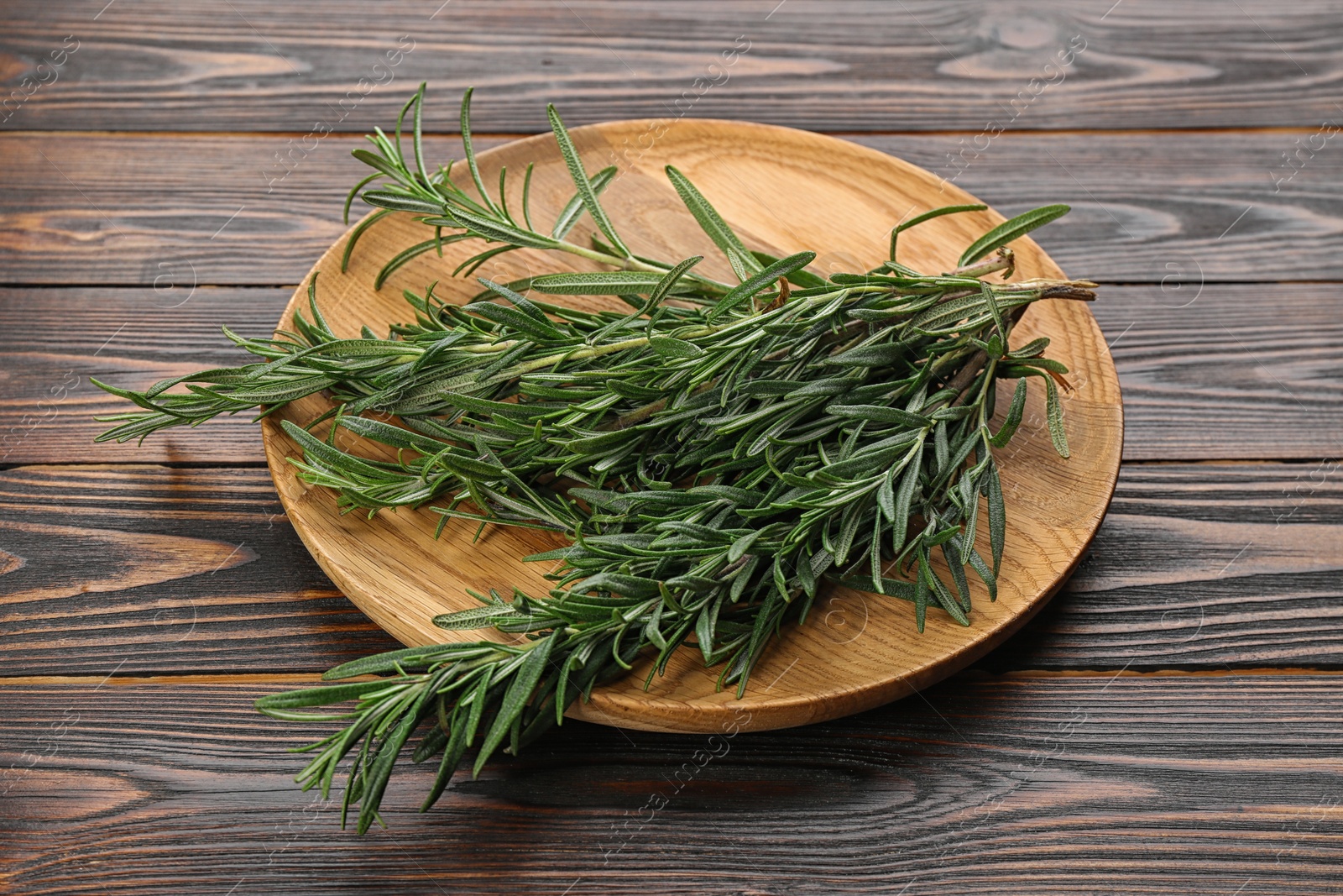 Photo of Bunch of fresh rosemary on wooden table