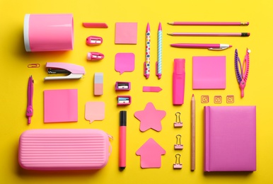 Flat lay composition with pink school stationery on yellow background. Back to school