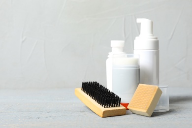 Photo of Shoe care accessories on wooden table against light background