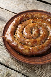 Photo of Plate with tasty homemade sausages on wooden table, closeup