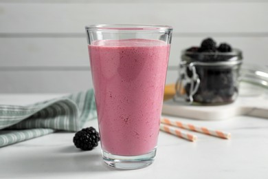 Photo of Glass of blackberry smoothie on white table
