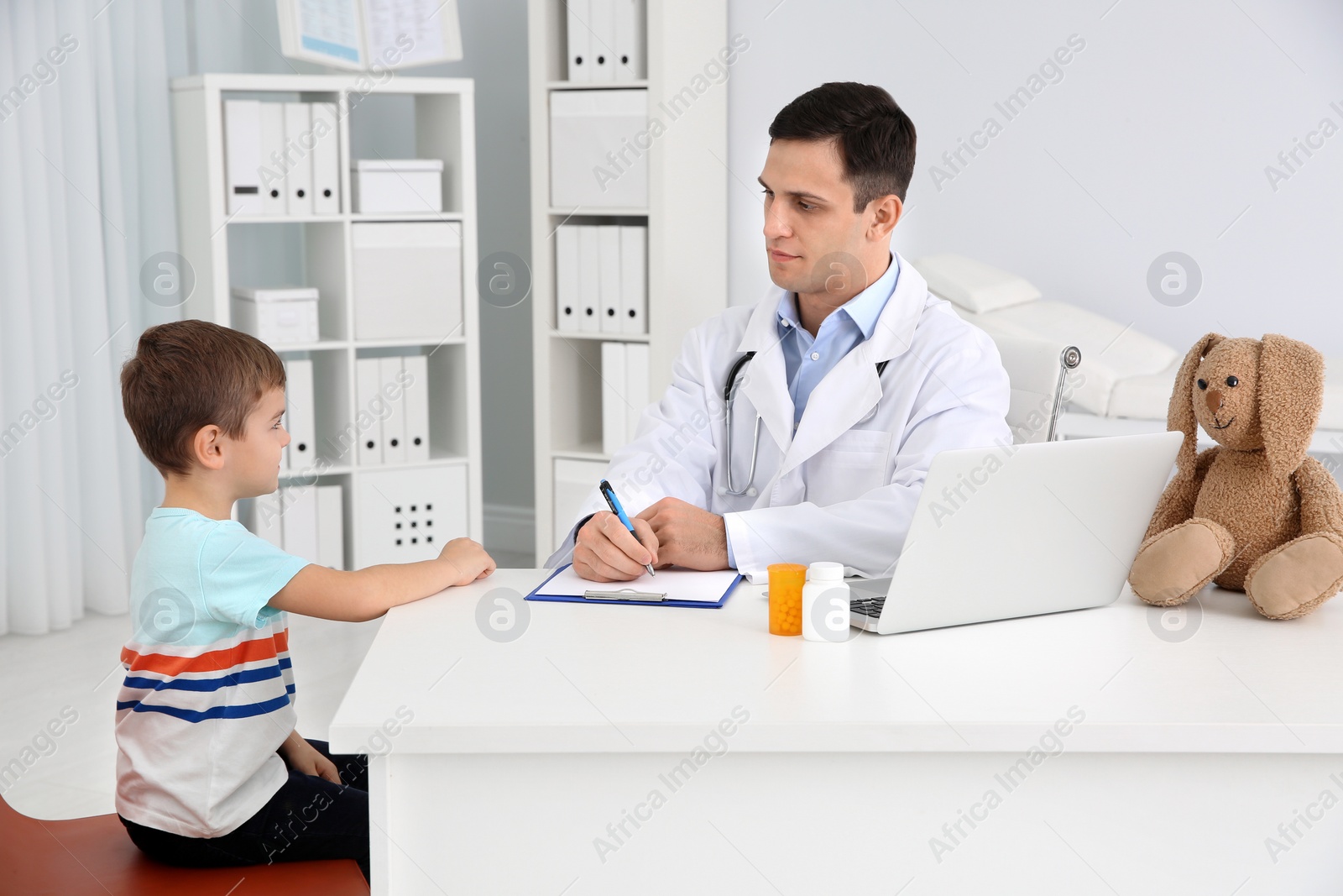 Photo of Children's doctor working with little patient in hospital