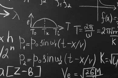 Photo of Many different math formulas written on chalkboard, closeup