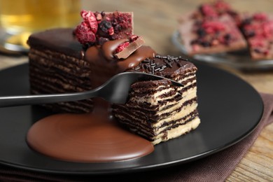Photo of Eating tasty chocolate cake at table, closeup