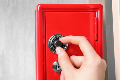 Photo of Man opening steel safe with mechanical combination lock, closeup