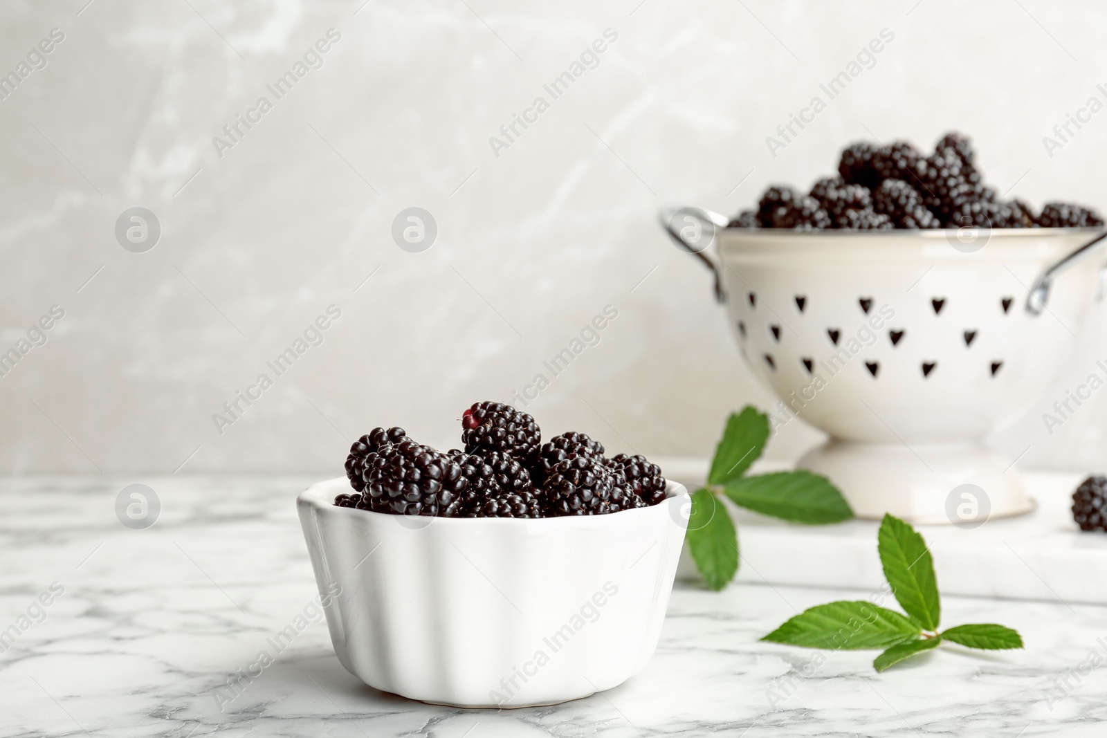 Photo of Bowl of fresh blackberry on marble table