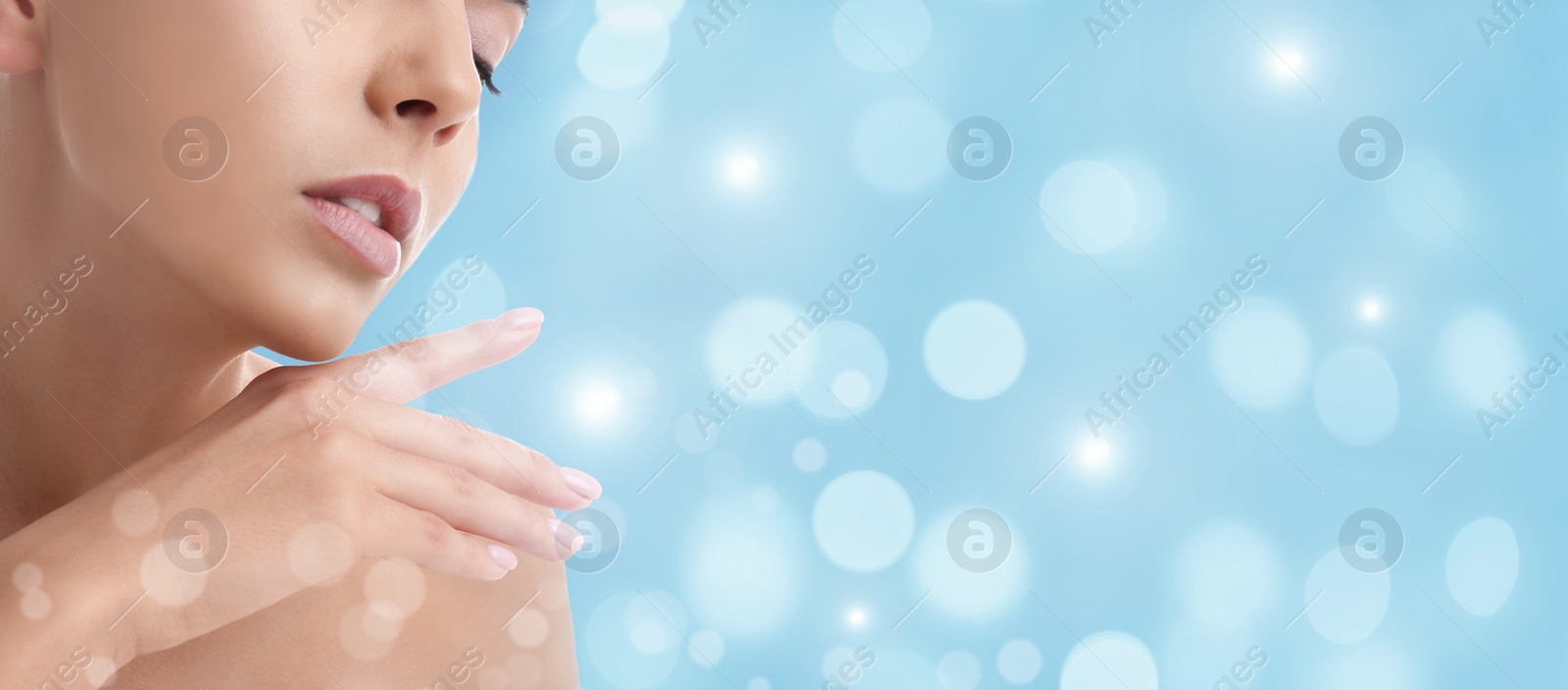 Image of Young woman with smooth skin on light blue background, bokeh effect. Space for text