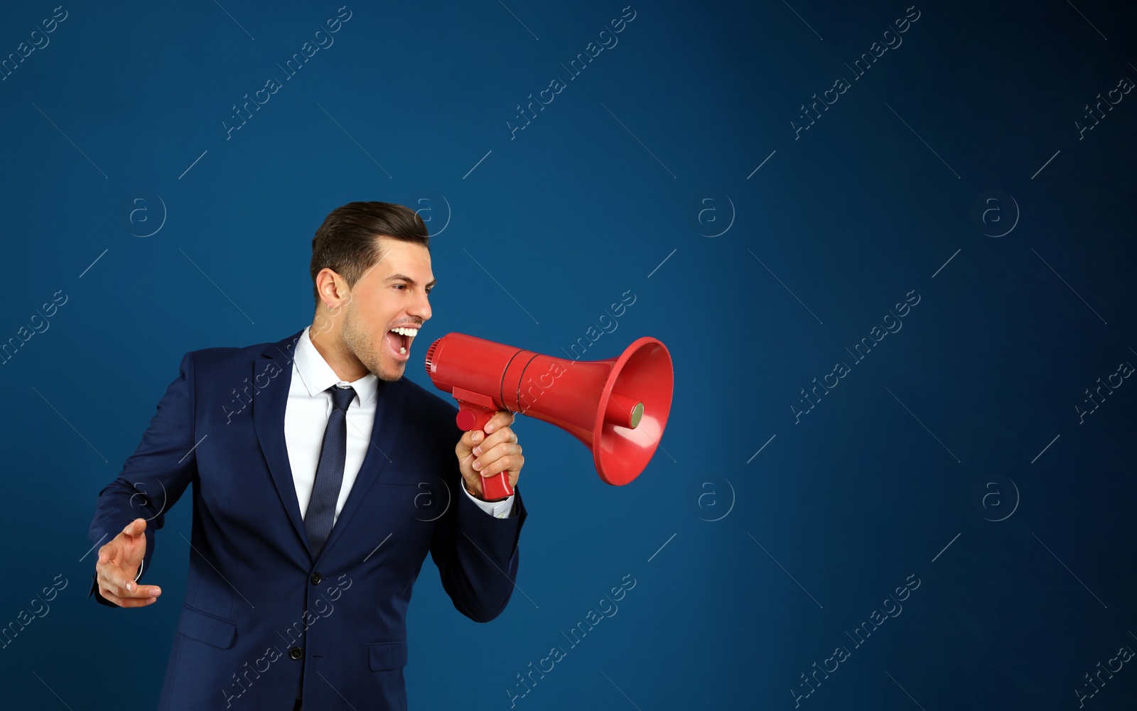 Photo of Handsome man with megaphone on blue background