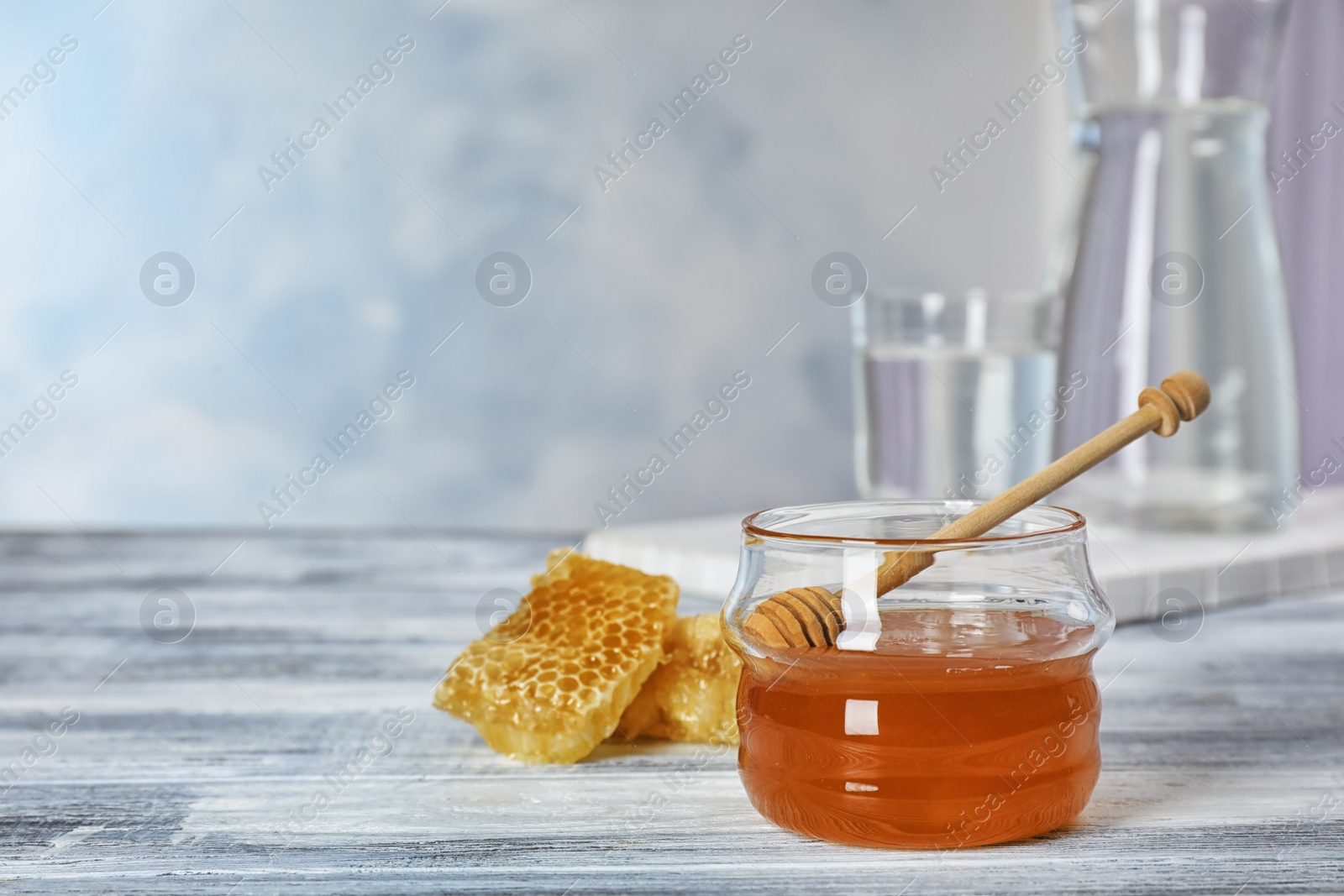 Photo of Jar of honey and dipper on table