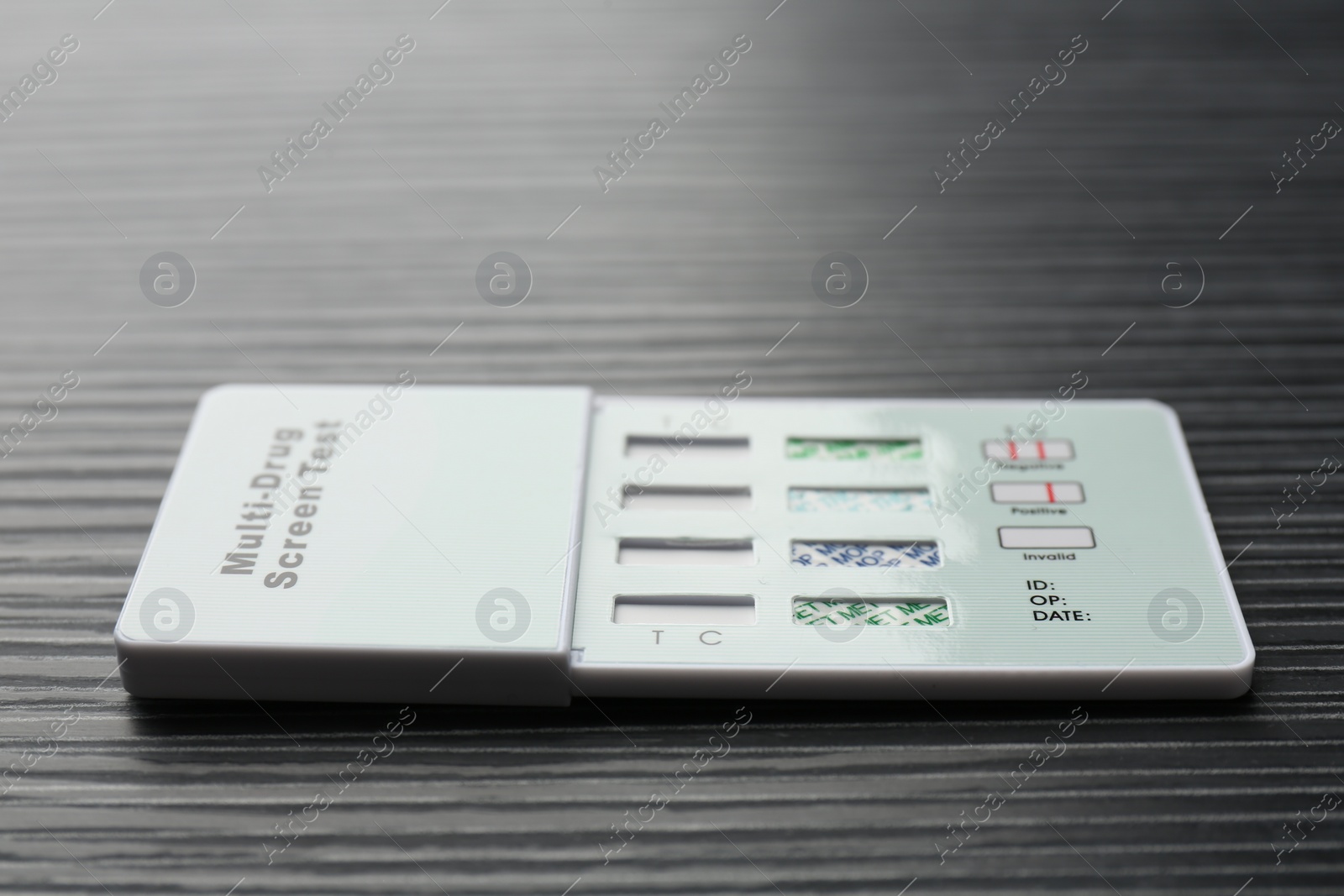 Photo of Multi-drug screen test on black wooden table, closeup