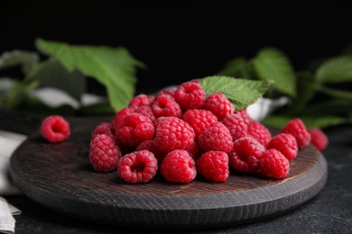 Photo of Wooden board with fresh ripe raspberries on table, closeup