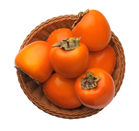 Photo of Delicious ripe persimmons in wicker basket on white background, top view