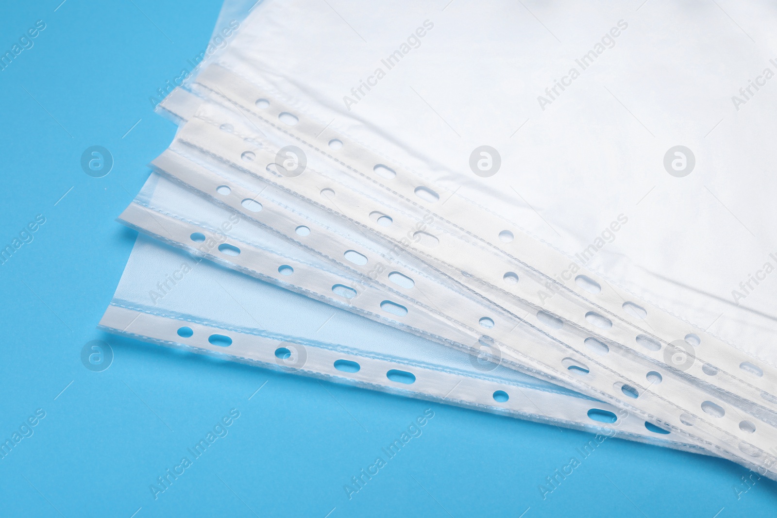 Photo of Punched pockets on light blue background, closeup