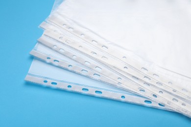 Photo of Punched pockets on light blue background, closeup