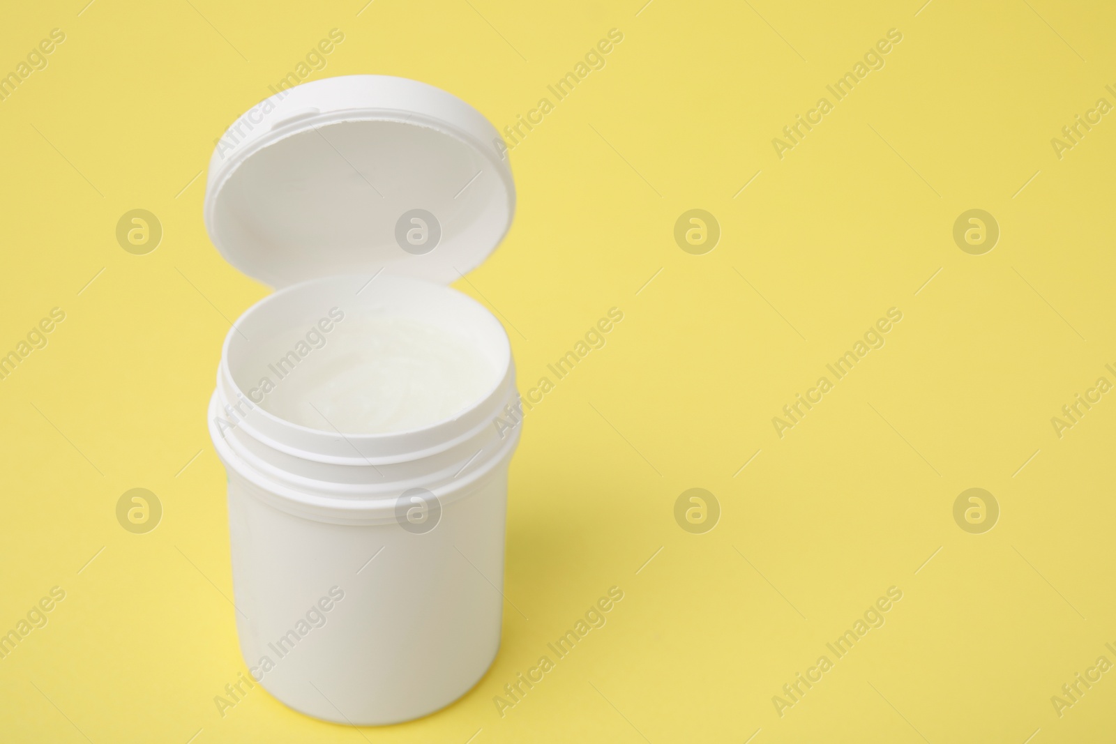 Photo of Jar of petroleum jelly on yellow background, space for text