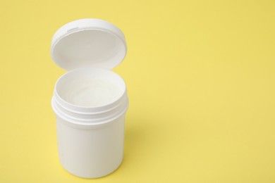 Jar of petroleum jelly on yellow background, space for text