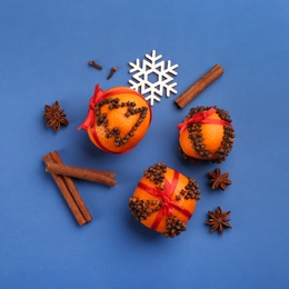 Photo of Flat lay composition with pomander balls made of fresh tangerines on blue background