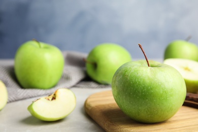 Composition with fresh ripe green apple on wooden board against blue background, closeup view. Space for text