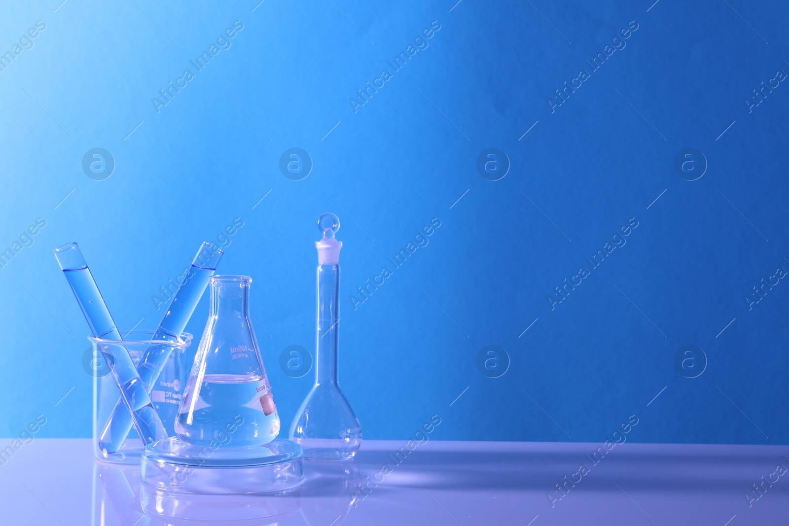 Photo of Laboratory analysis. Different glassware on table against light blue background