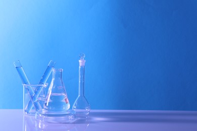 Laboratory analysis. Different glassware on table against light blue background