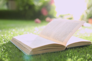 Open book on green grass in park