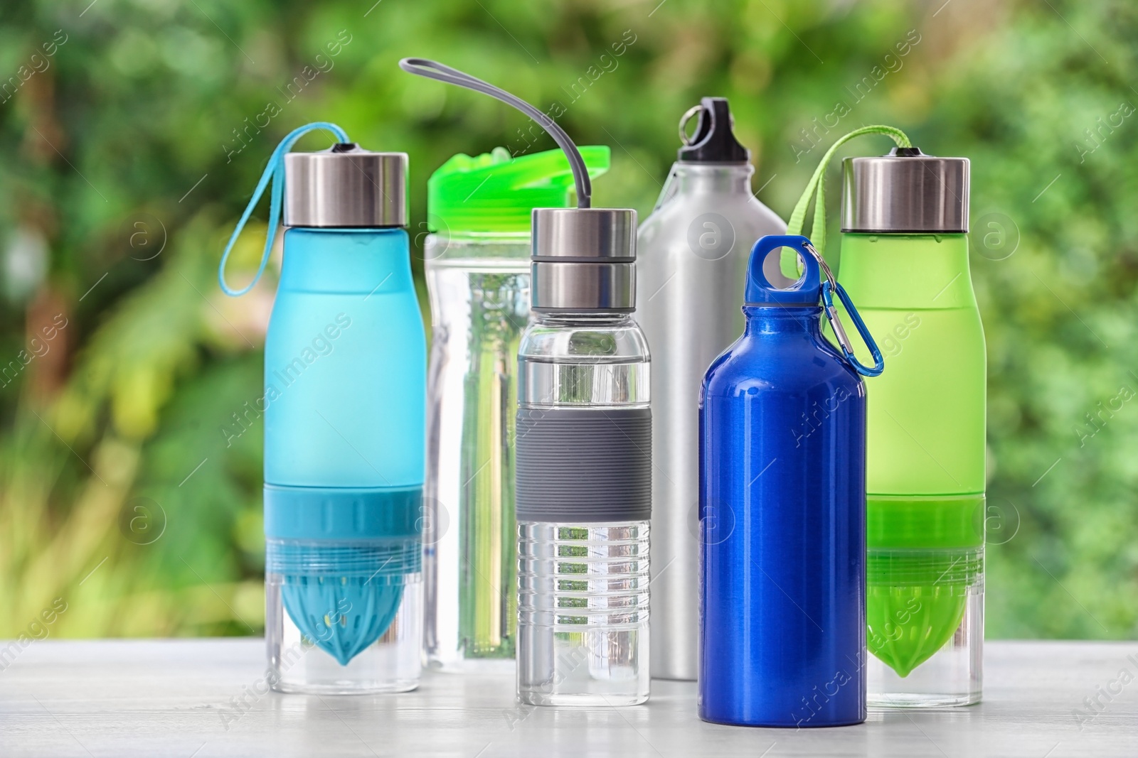 Photo of Sports water bottles on table against blurred background