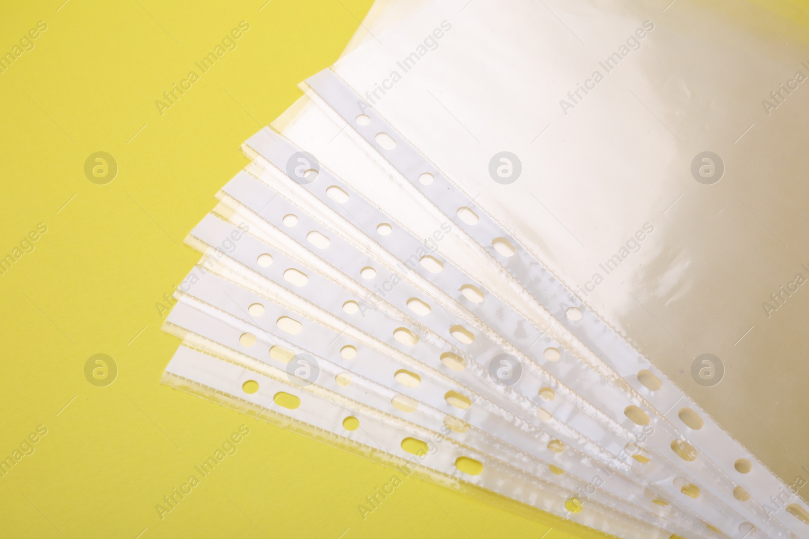 Photo of Empty punched pockets on yellow background, flat lay