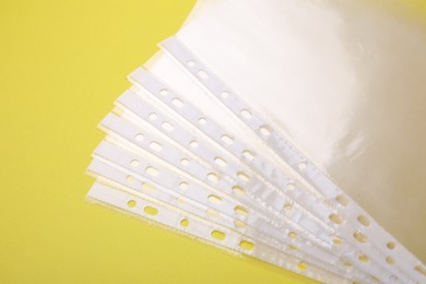 Photo of Empty punched pockets on yellow background, flat lay