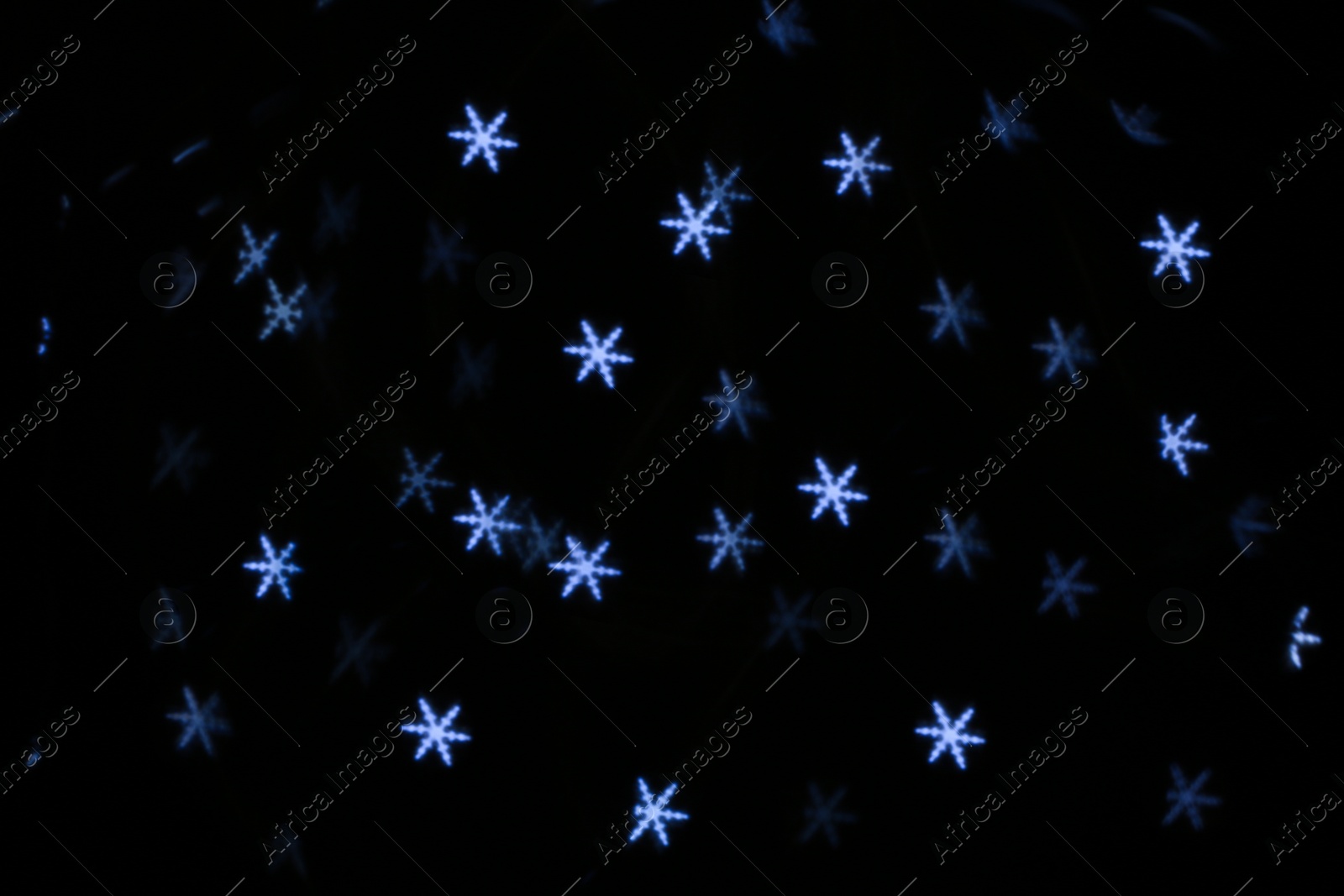 Photo of White snowflake shaped glitter on black background
