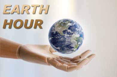 Image of Take care of Earth, turn off lights for hour. Wooden mannequin hand with globe illustration on light background