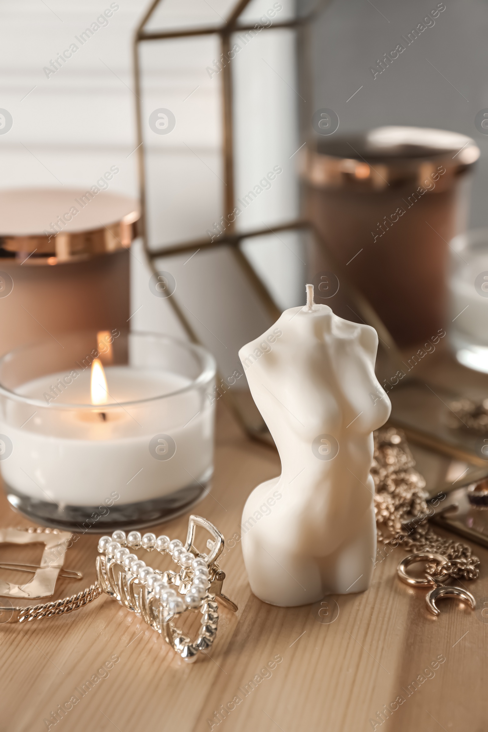 Photo of Beautiful female body shaped candle on wooden table. Stylish decor