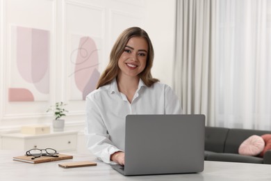 Photo of Happy woman with laptop on white table