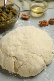 Making delicious pesto bread. Raw dough on grey table, closeup