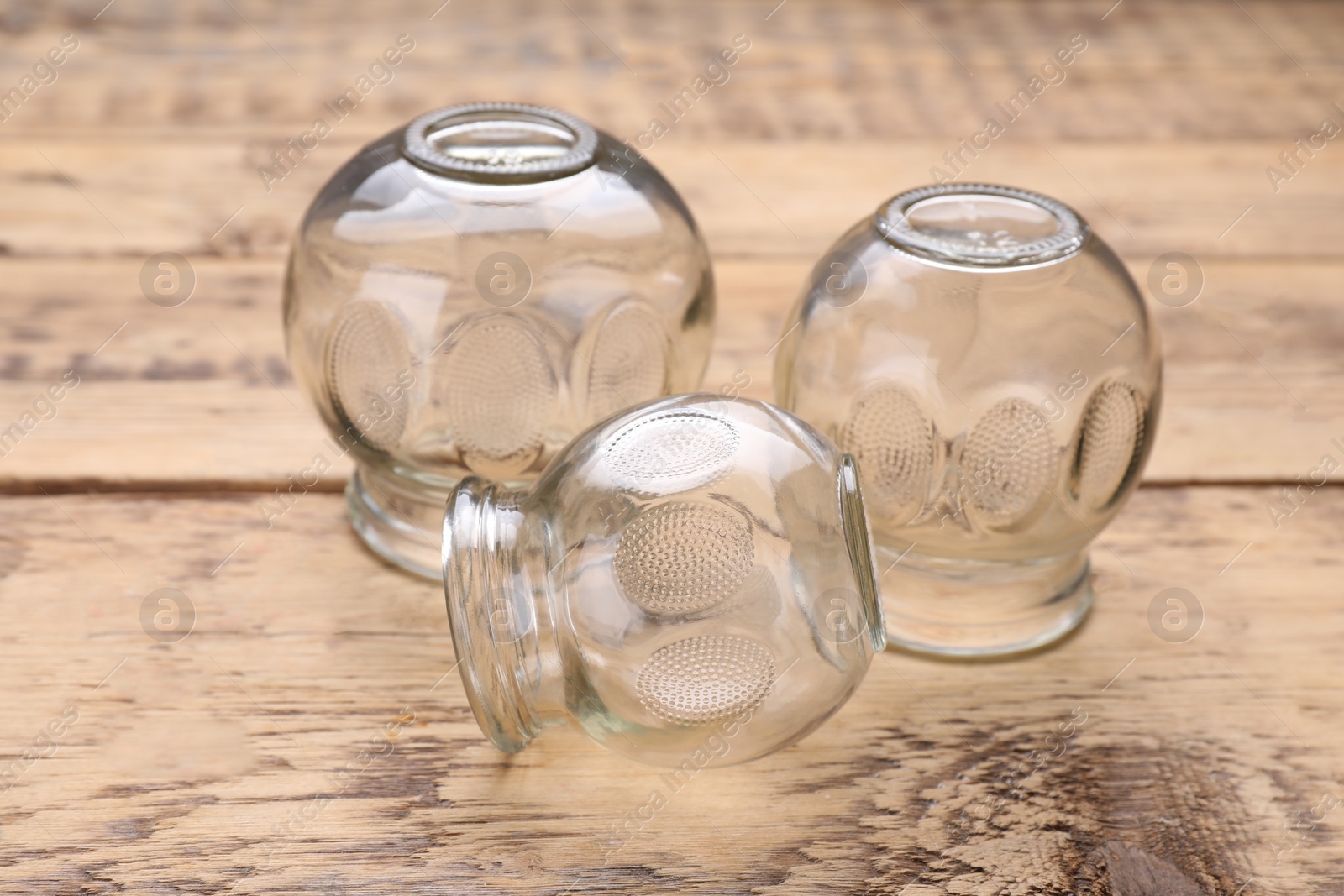 Photo of Glass cups on wooden table, closeup. Cupping therapy