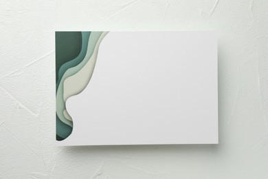 Blank invitation card on white table, top view