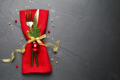 Photo of Cutlery set on grey table, top view with space for text. Christmas celebration