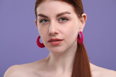 Portrait of beautiful woman with freckles on purple background