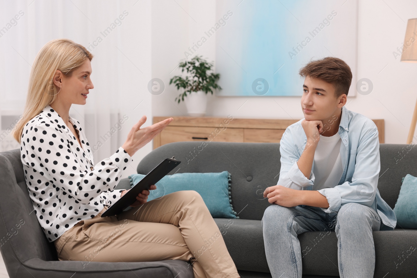 Photo of Psychologist working with teenage boy in office