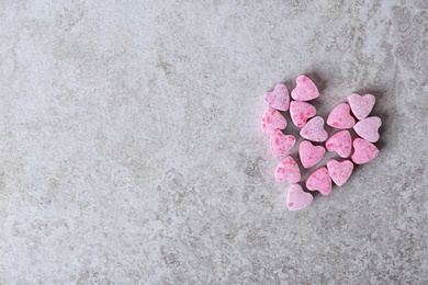 Photo of Small heart shaped candies and space for text on gray background, top view