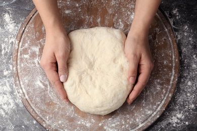 Photo of Female baker preparing bread dough at table, top view