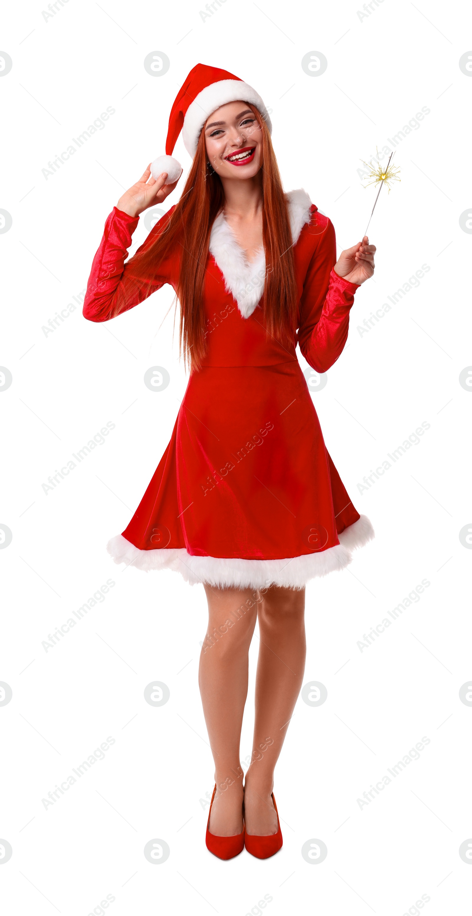 Photo of Young woman in red dress and Santa hat with burning sparkler on white background. Christmas celebration