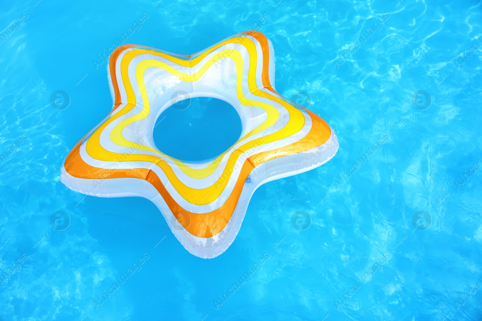 Photo of Inflatable ring floating in swimming pool on sunny day