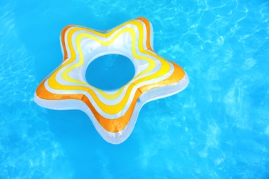 Photo of Inflatable ring floating in swimming pool on sunny day