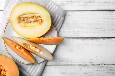 Tasty colorful ripe melons on white wooden table, flat lay. Space for text