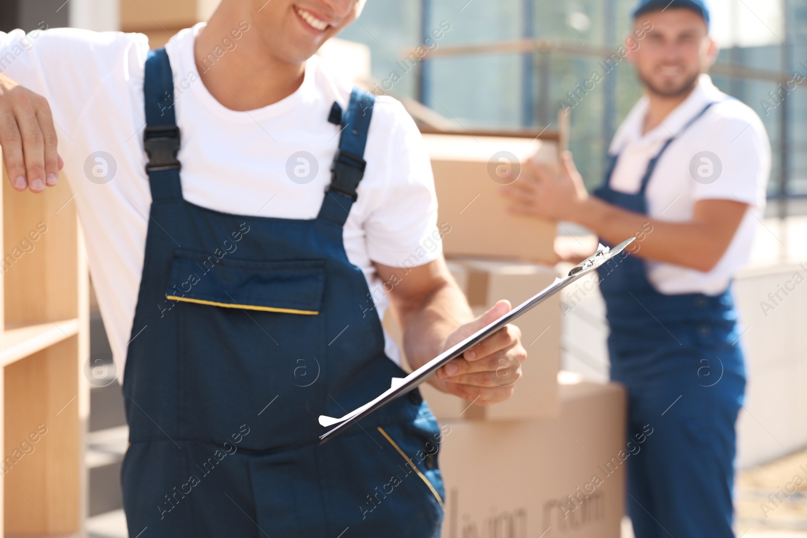 Photo of Male mover with clipboard outdoors on sunny day, closeup