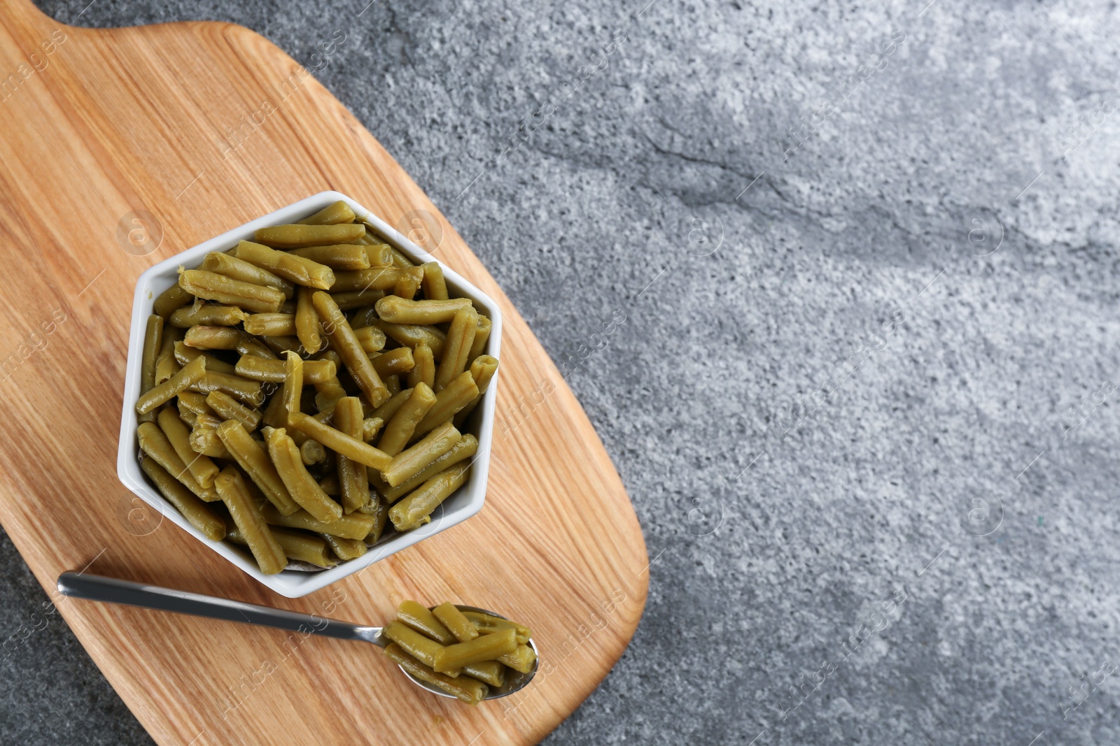 Photo of Canned green beans on grey table, top view. Space for text